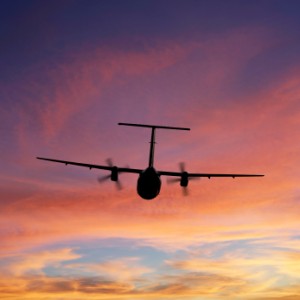 propeller airplane flying at sunset